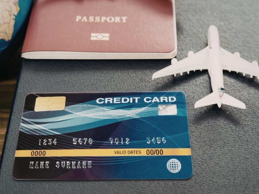 Several travel rewards credit cards laid out flat showing points and miles earning options for free flights