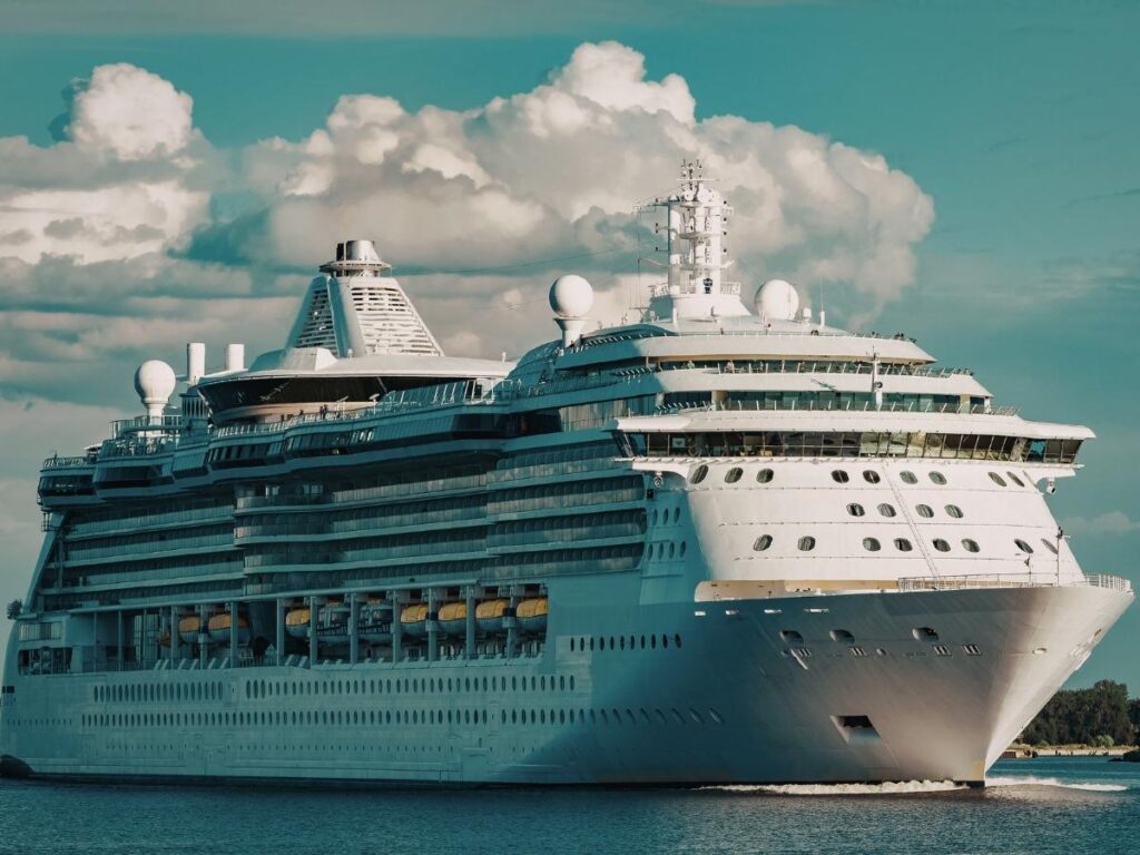 Cruise ship sailing past glaciers and snow-capped mountains in Alaska