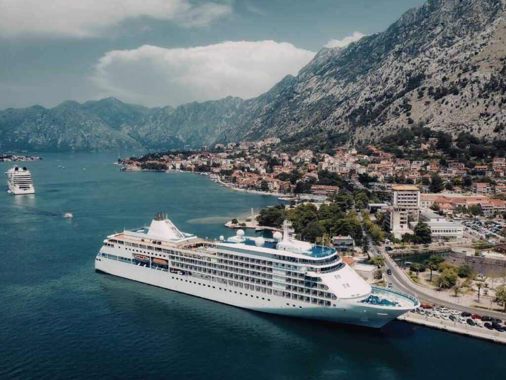 Cruise ship anchored near a whitewashed coastal village in the Mediterranean