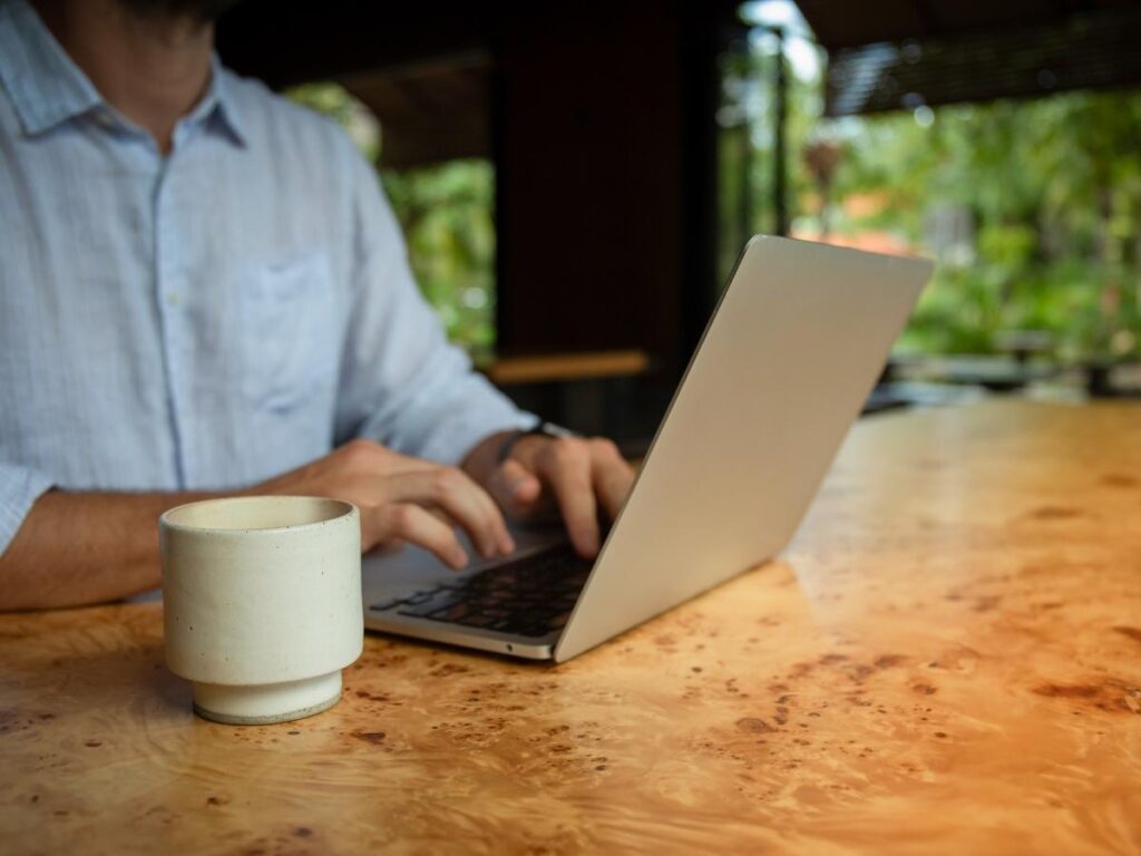 Remote worker focused at a laptop inside a bright modern coworking space while traveling abroad