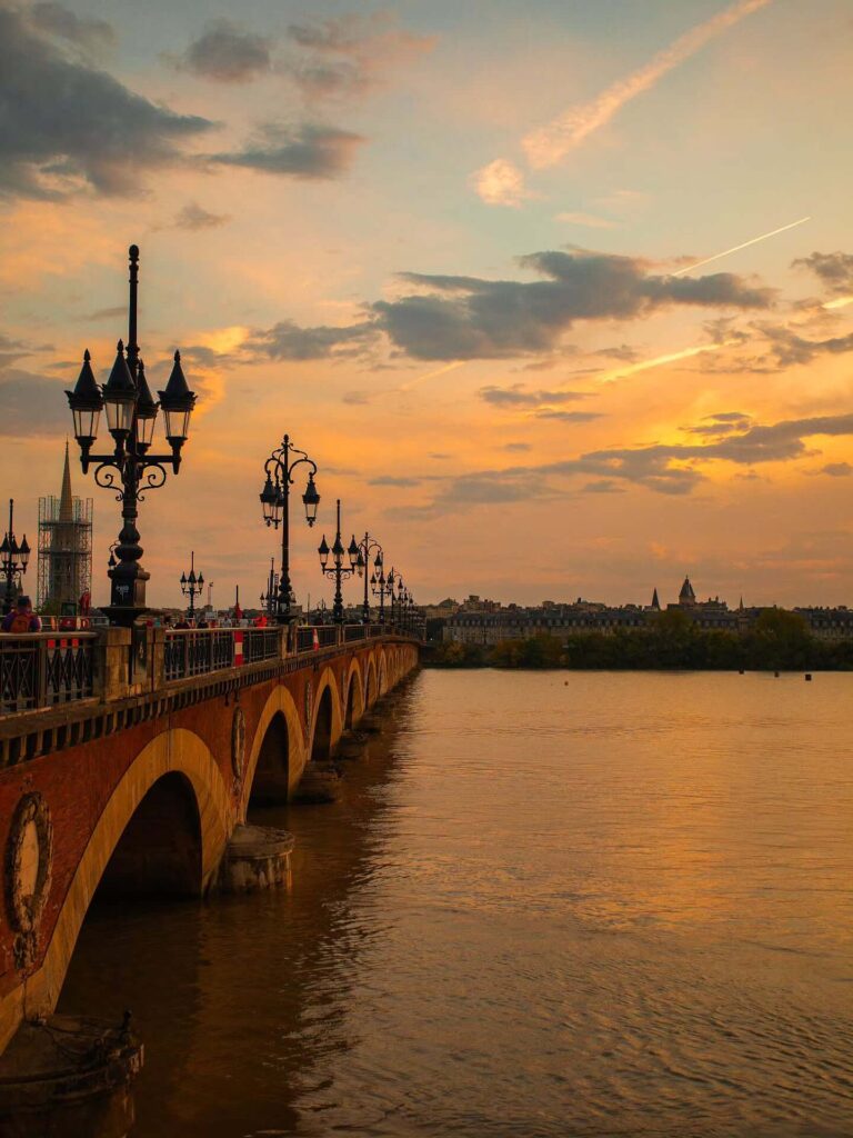 Sunset over the river in Bordeaux with people relaxing nearby