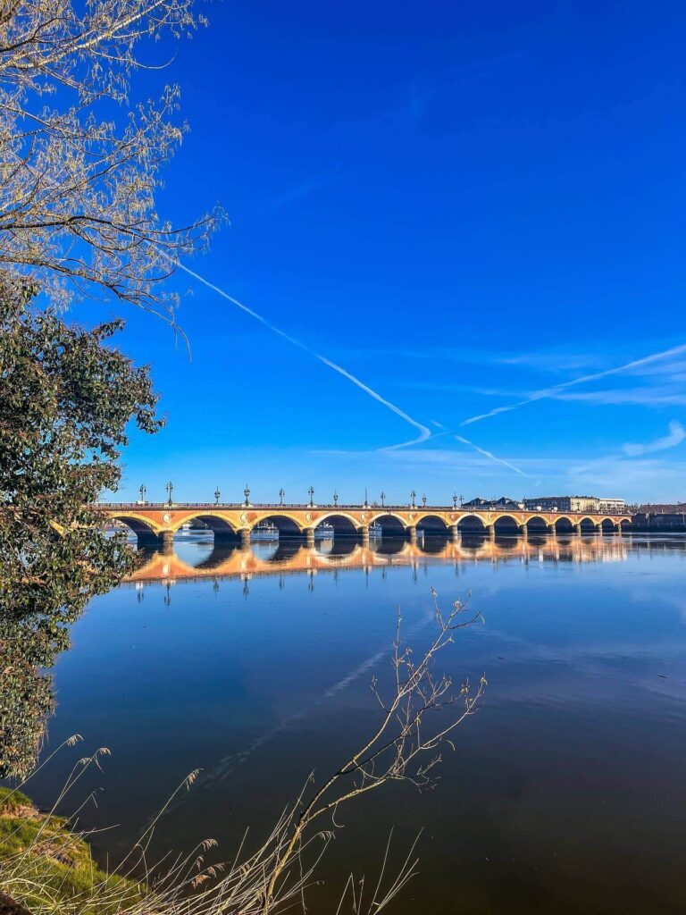People walking along the Garonne river at sunset in Bordeaux