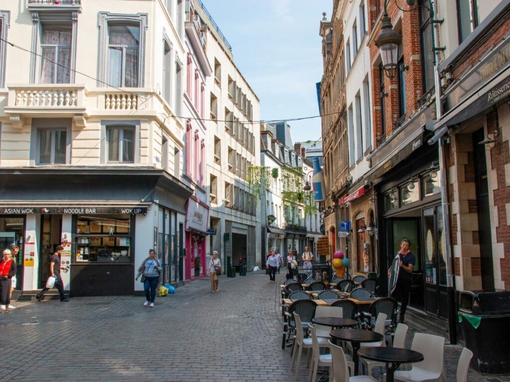 Google Maps Street View showing a walkable city street with cafes and pedestrians used for pre-booking hotel research
