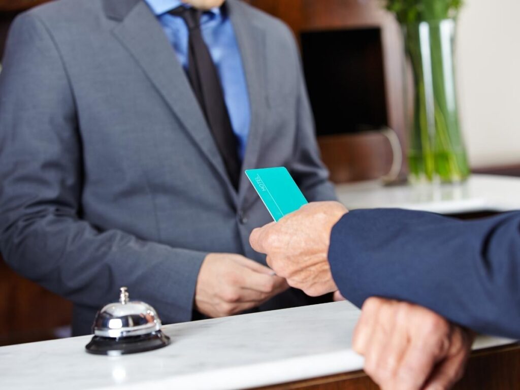 Guest handing over a credit card at hotel front desk during checkout
