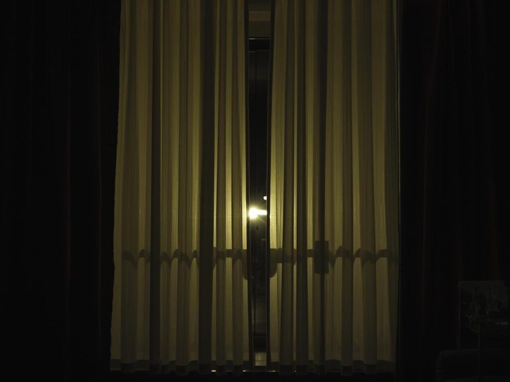 Hotel curtains clipped together in the middle to block out streetlight at night