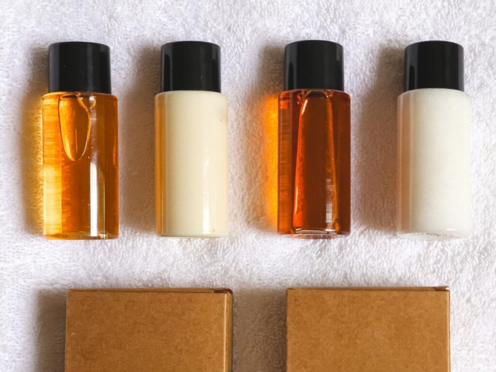 Hotel bathroom amenities including small bottles of shampoo conditioner and soap on a marble vanity