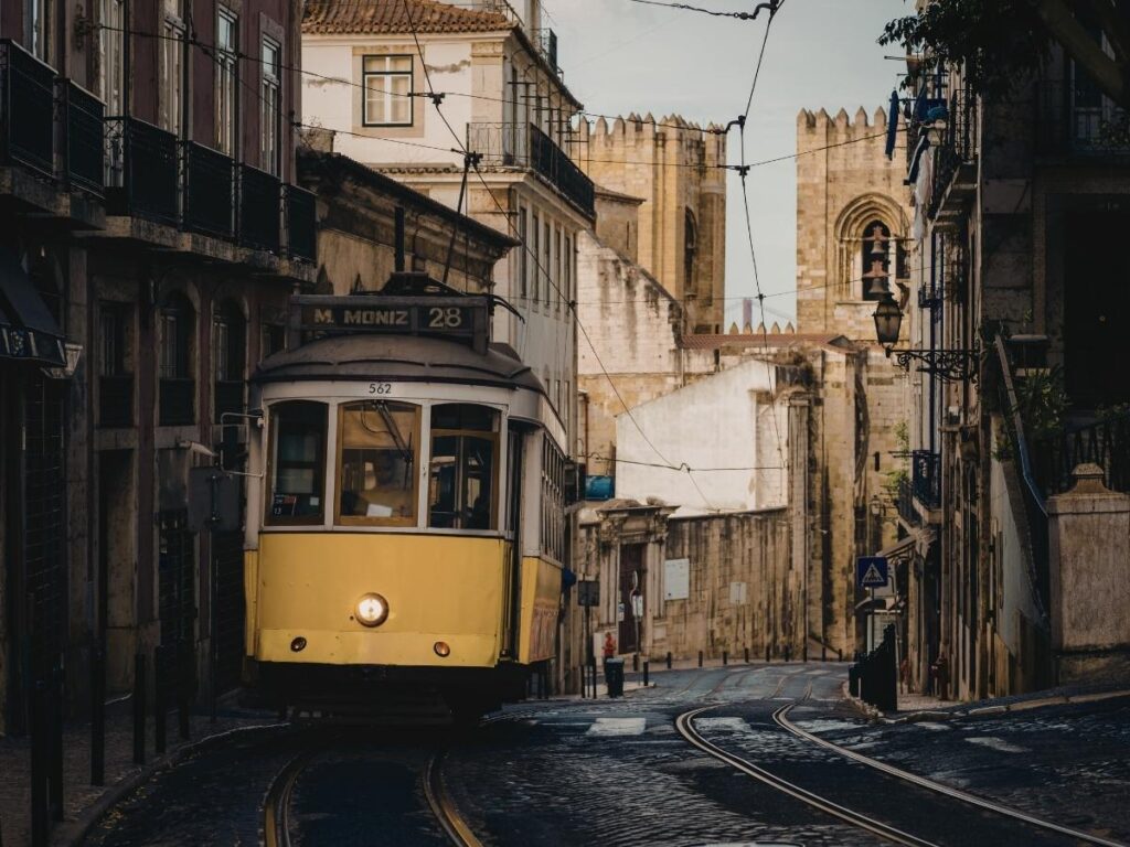 Colorful tiled buildings and trams along a hilly street in Lisbon Portugal