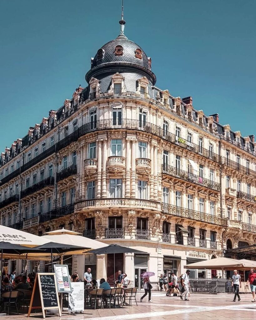 Relaxed café scene in Montpellier with people sitting in a small square