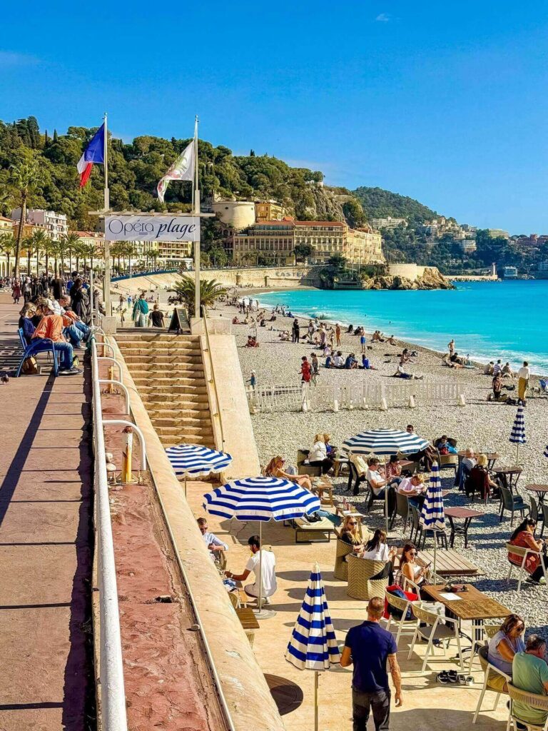 People sitting on chairs facing the sea in Nice France