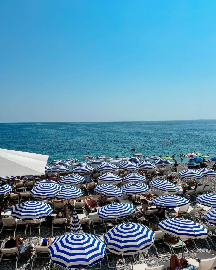 People relaxing on chairs facing the sea in Nice France