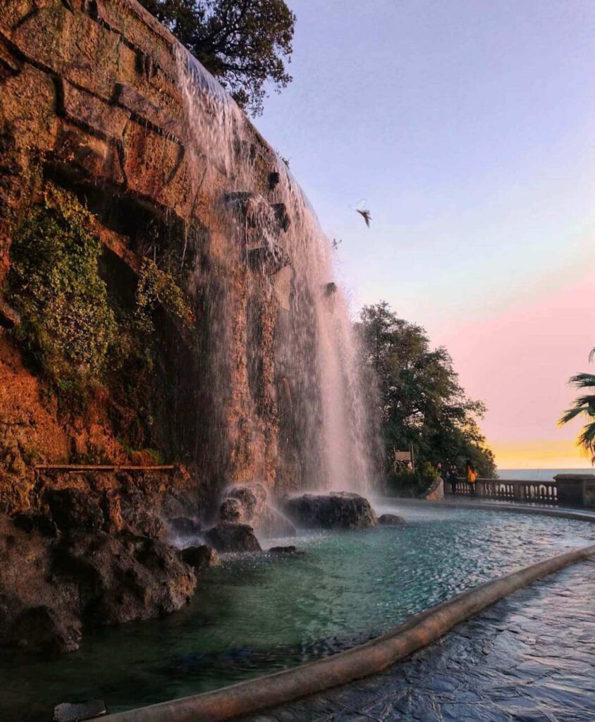 Sunset over the Mediterranean Sea in Nice with people along the promenade