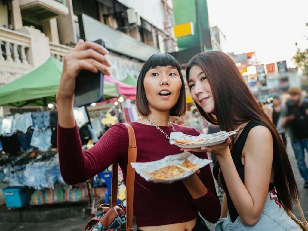 Two travelers taking a quick photo together at the start of a day trip in a busy city market