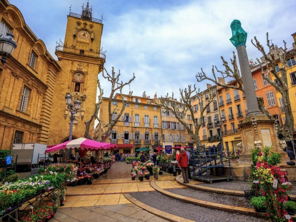 Afternoon market in Aix-en-Provence with people browsing local stalls