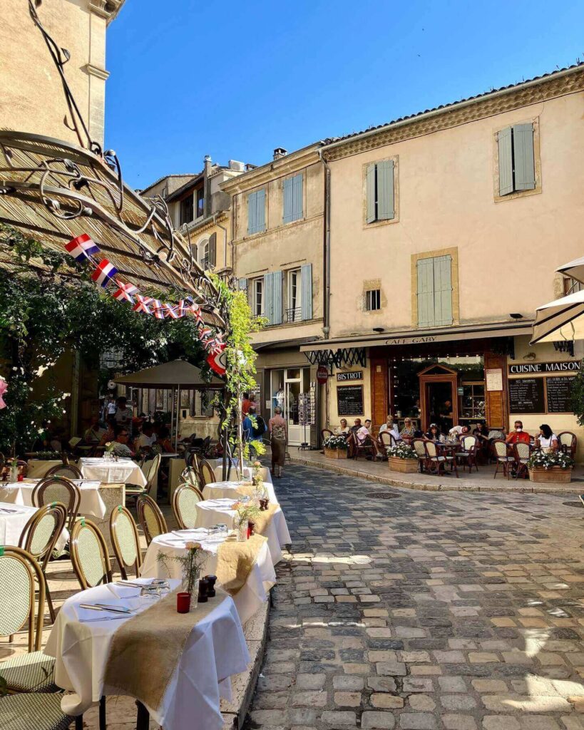 Busy street in Aix-en-Provence during summer with cafés and people