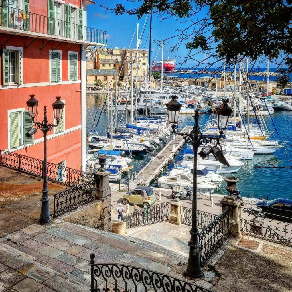 Bastia Old Port at golden hour with warm light reflecting on buildings and water