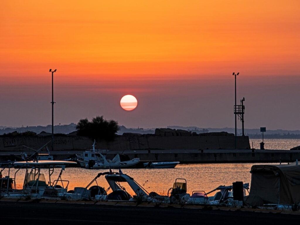 Sunset at Bastia Old Port with warm light reflecting on water and buildings
