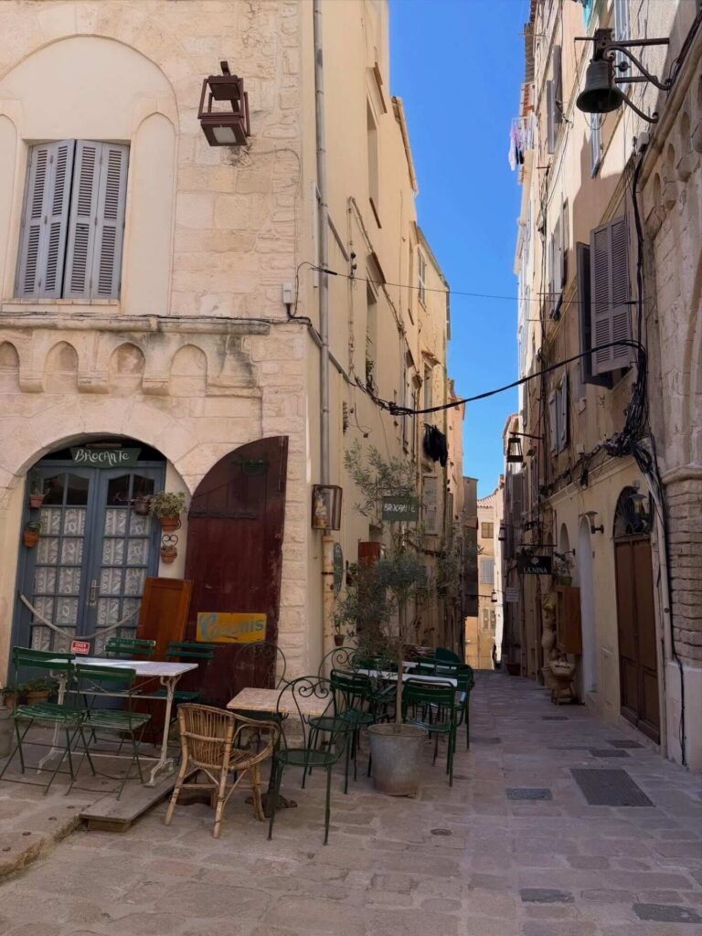 Narrow street in Bonifacio old town opening up to a sea view