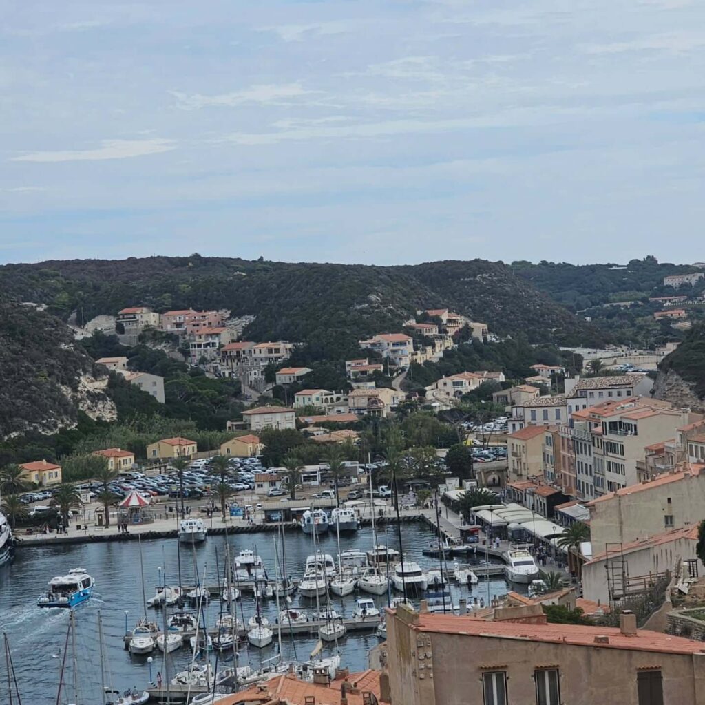 Busy summer atmosphere at Bonifacio marina with boats and restaurants
