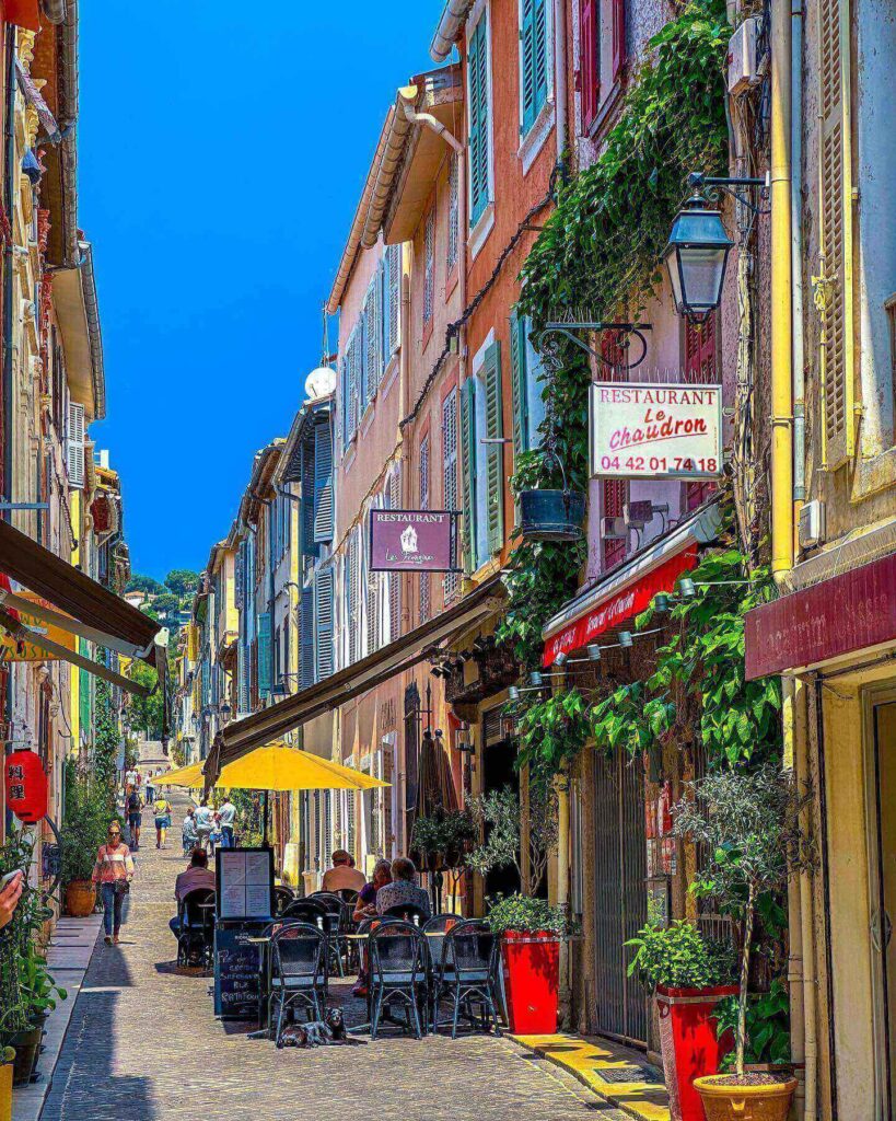 Quiet morning at Cassis harbor with cafés and boats along the waterfront