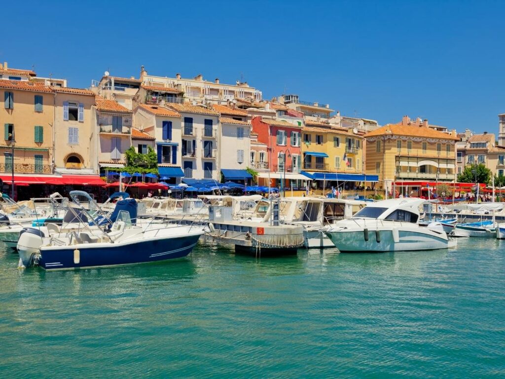Cassis harbor with pastel buildings, boats, and cafés along the waterfront