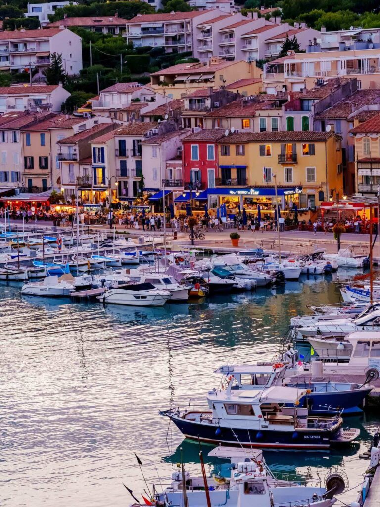 Walking along Cassis harbor with cafés and boats in the town center