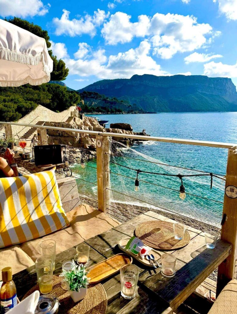 Outdoor café at Cassis harbor with people relaxing by the water