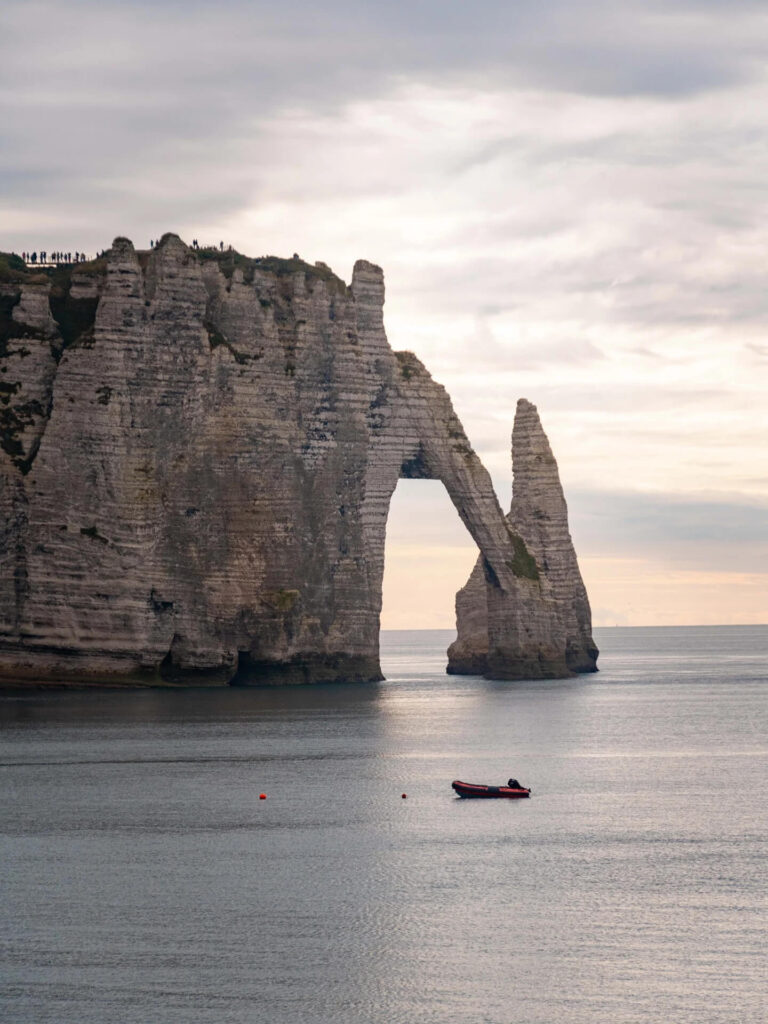 Quiet morning view of Étretat cliffs and beach with soft light