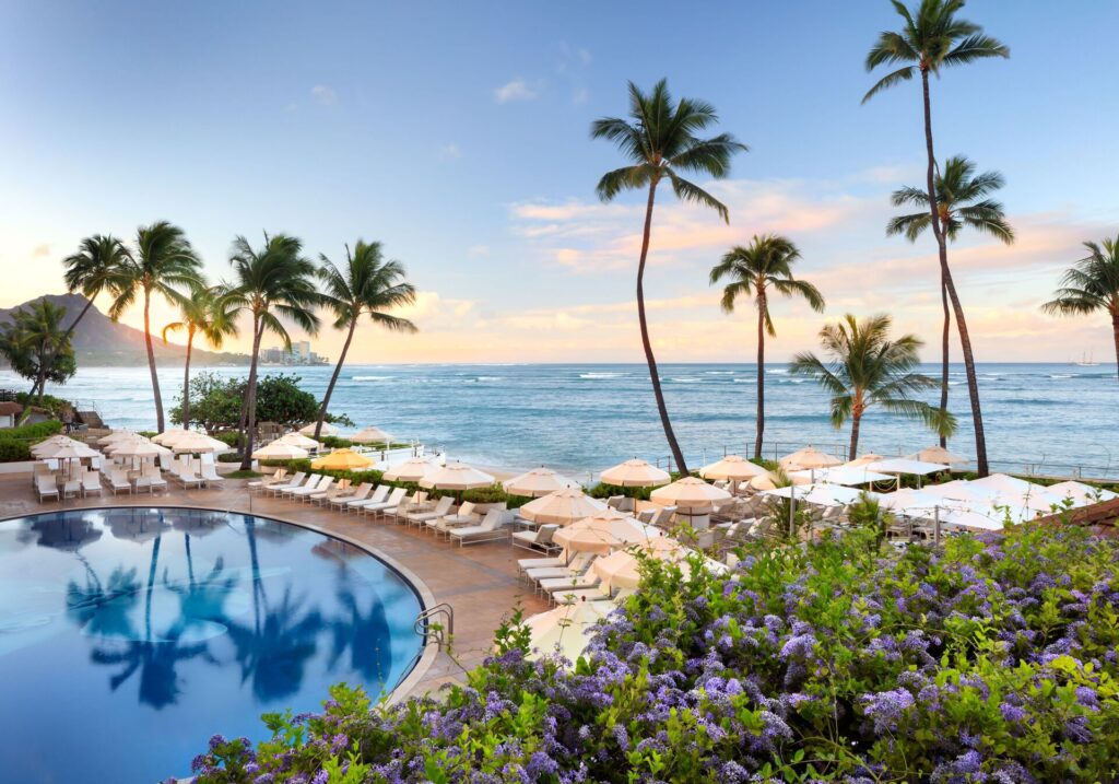 Exterior view of Halekulani in Waikiki, featuring elegant beachfront luxury, pristine ocean views, white modern architecture, and a serene upscale resort atmosphere.