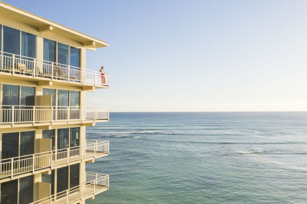 Exterior view of Kaimana Beach Hotel in Honolulu, featuring a boutique beachfront setting, Diamond Head views, relaxed tropical vibe, and direct access to a quiet stretch of Waikiki Beach.