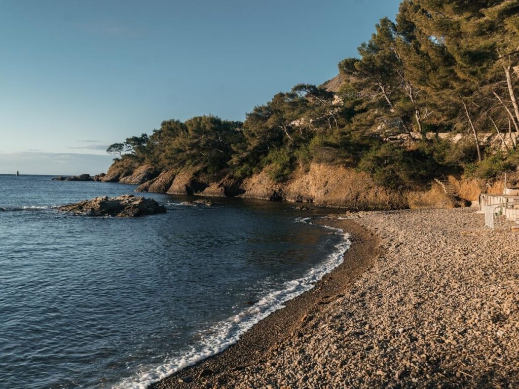 People relaxing on a sandy beach in La Ciotat with calm water