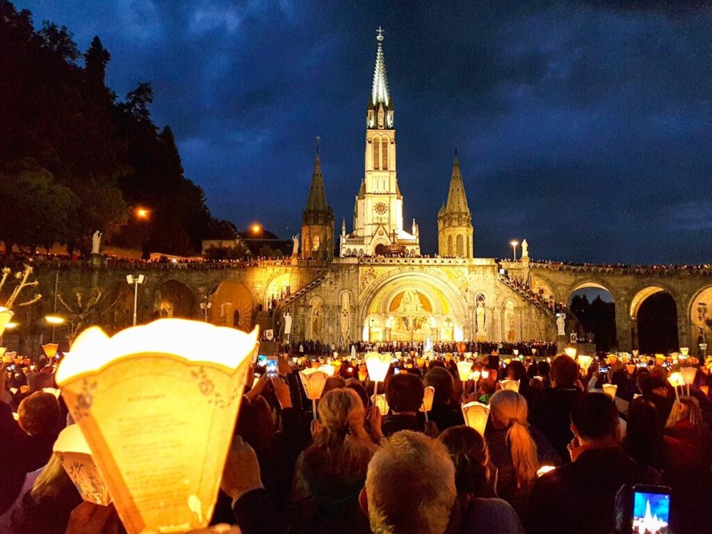 Close-up of candles being lit at Lourdes sanctuary