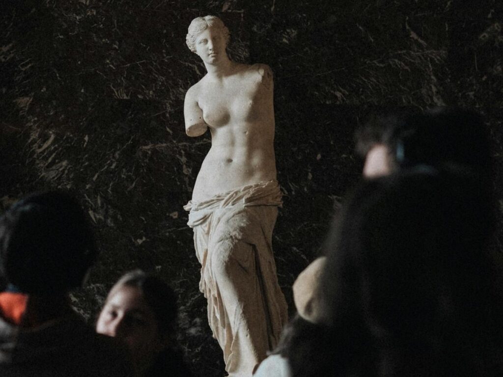 Venus de Milo statue displayed inside the Louvre Museum gallery