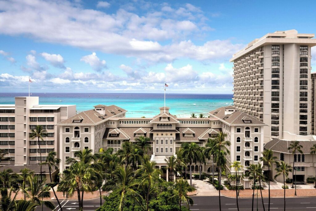 Exterior view of Moana Surfrider, A Westin Resort & Spa in Waikiki, featuring historic beachfront architecture, white colonial-style facade, banyan courtyard, and classic Hawaiian luxury ambiance.