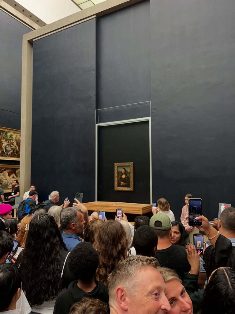 Visitors gathered around the Mona Lisa painting inside the Louvre Museum
