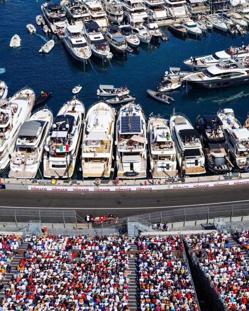Busy Monaco harbor during summer with crowds and yachts