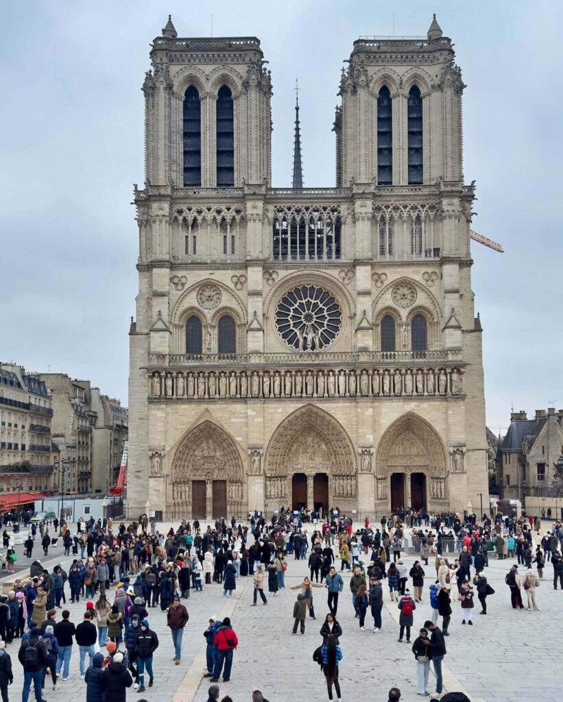 Crowded front square of Notre Dame with many visitors