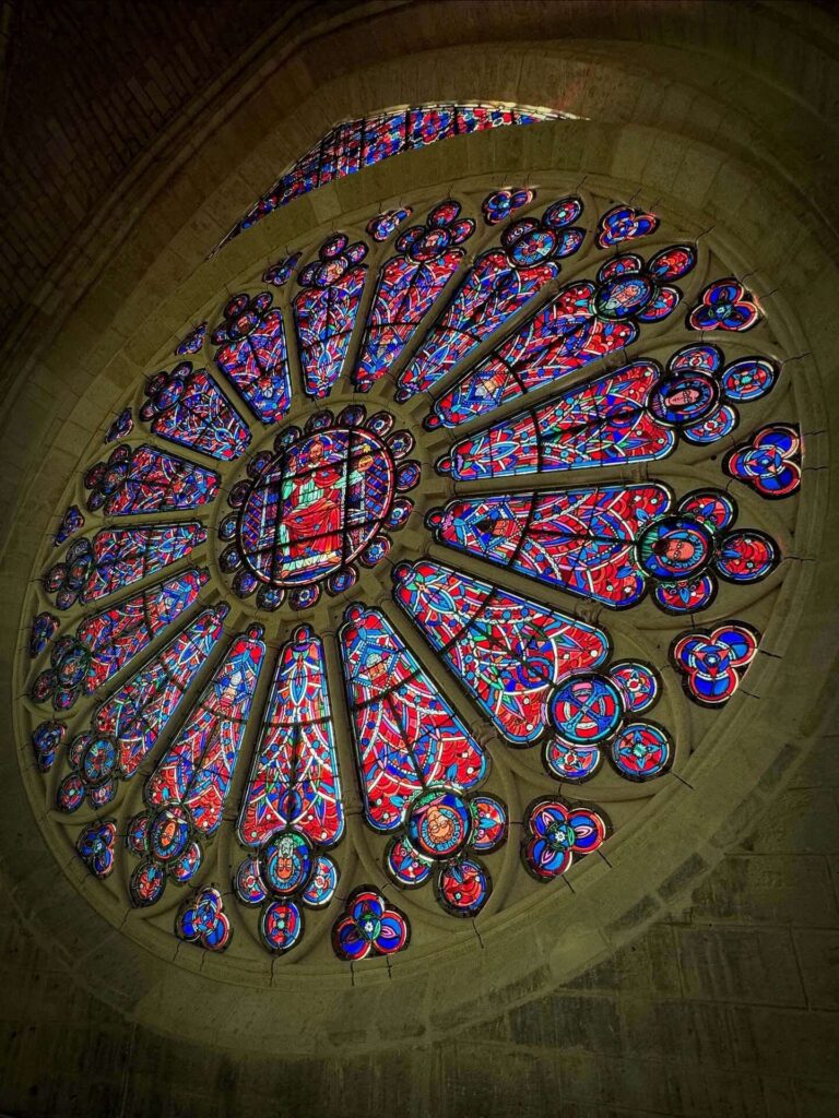 Sunlight passing through rose window inside Notre Dame cathedral