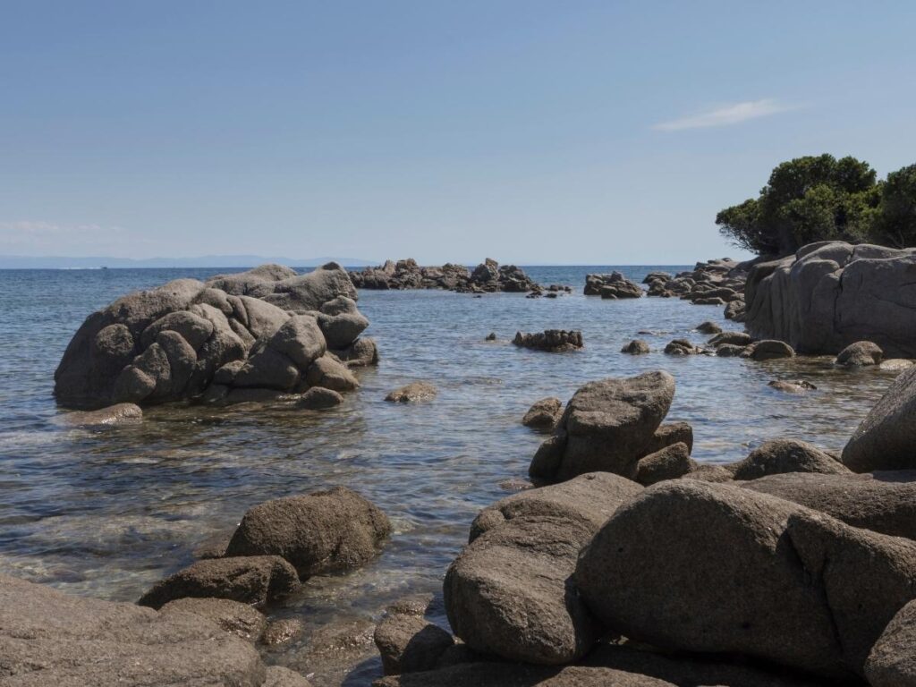 Clear shallow water and sandy shoreline at Sperone Beach