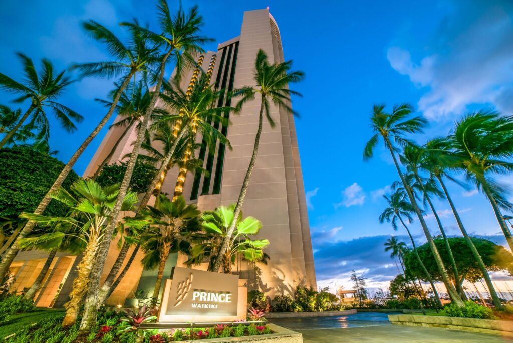 Exterior view of Prince Waikiki in Waikiki, featuring modern oceanfront high-rise design, panoramic harbor views, infinity pool, and upscale contemporary resort atmosphere.