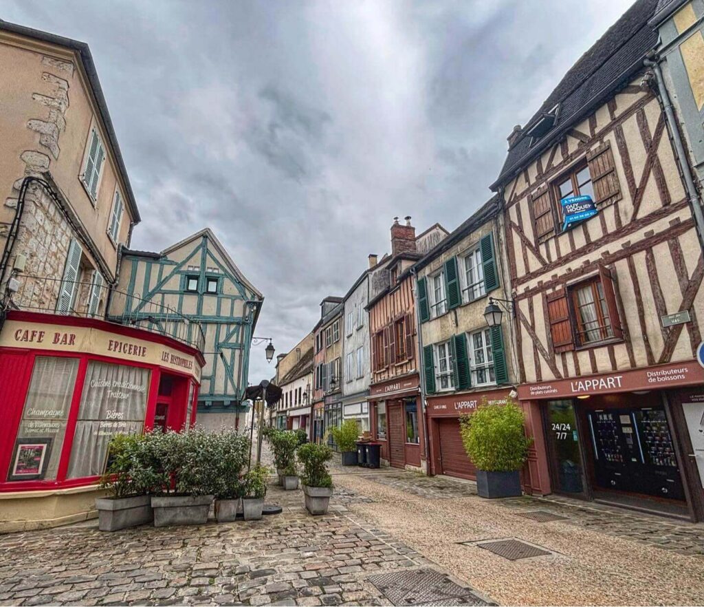Walking through a narrow street in Provins upper town with stone houses