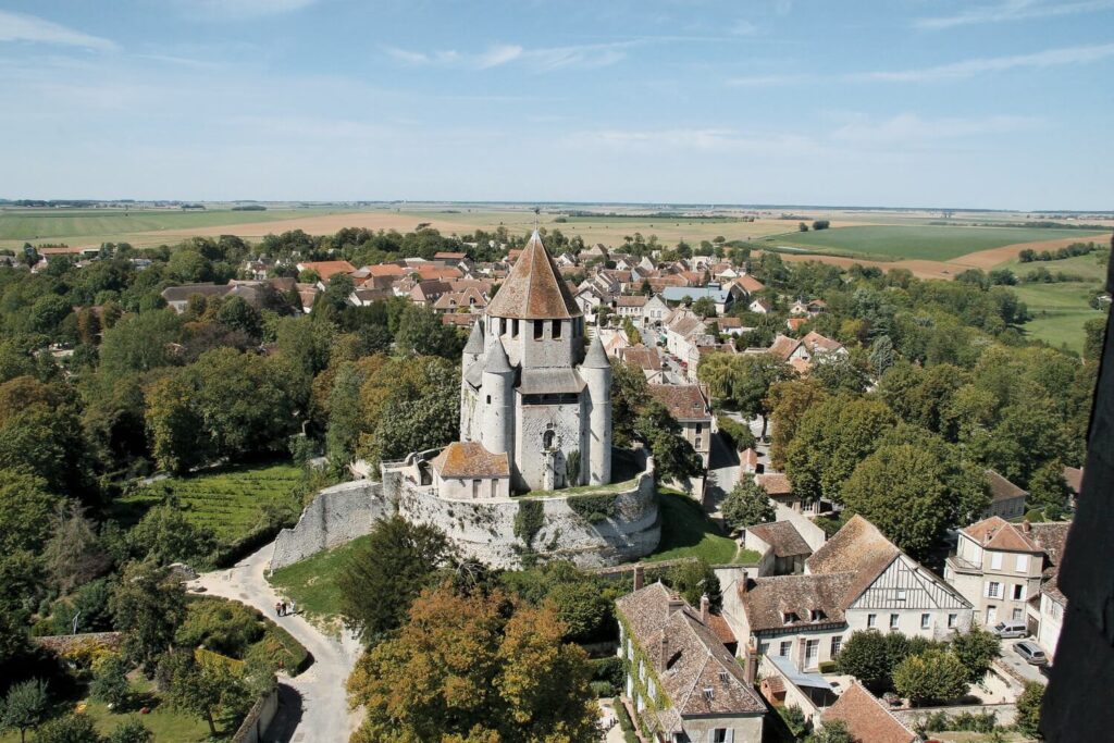 Walking through a quiet street in Provins with stone houses and wooden shutters