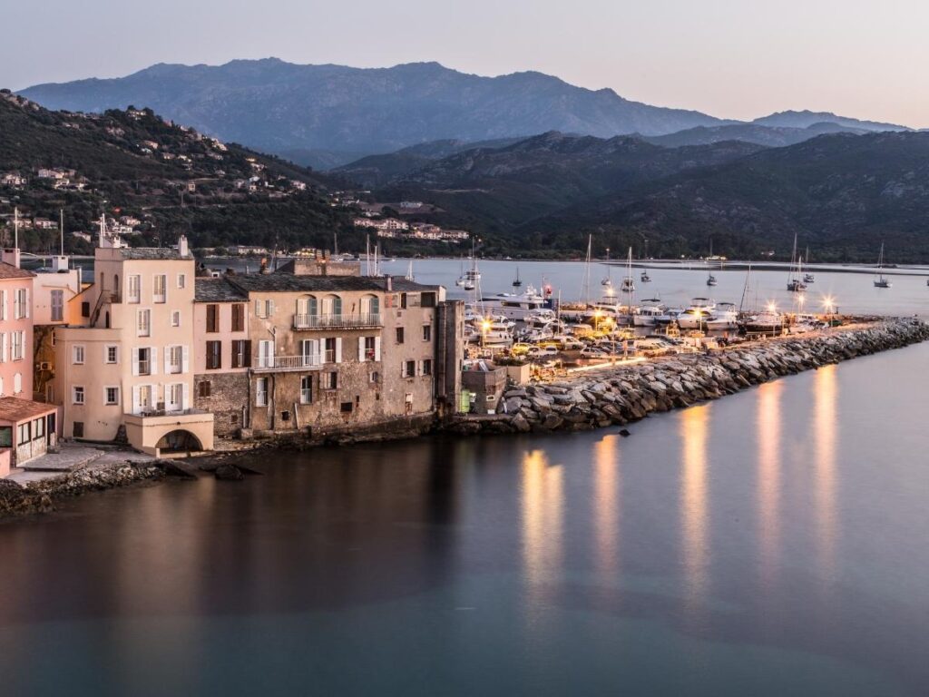 Walking along Saint Florent harbor with cafés and small coastal streets