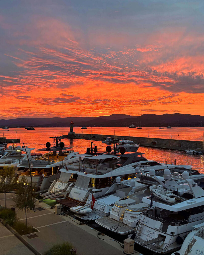 Evening view of Saint Tropez harbor with lights reflecting on the water