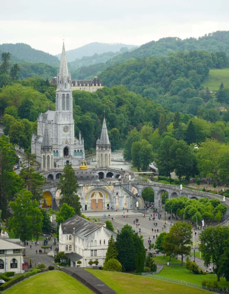 Wide view of the Sanctuary of Our Lady of Lourdes with visitors walking