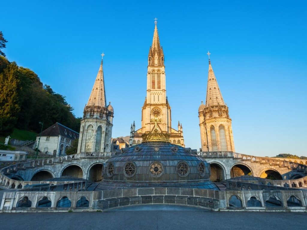 Wide view of the Sanctuary of Our Lady of Lourdes with visitors walking