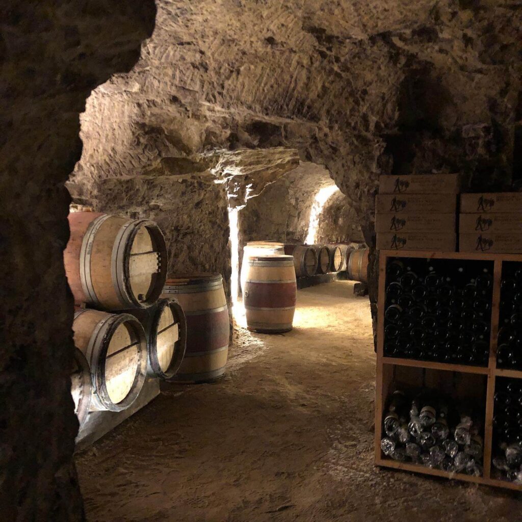 Underground wine caves in Saumur with rows of aging bottles