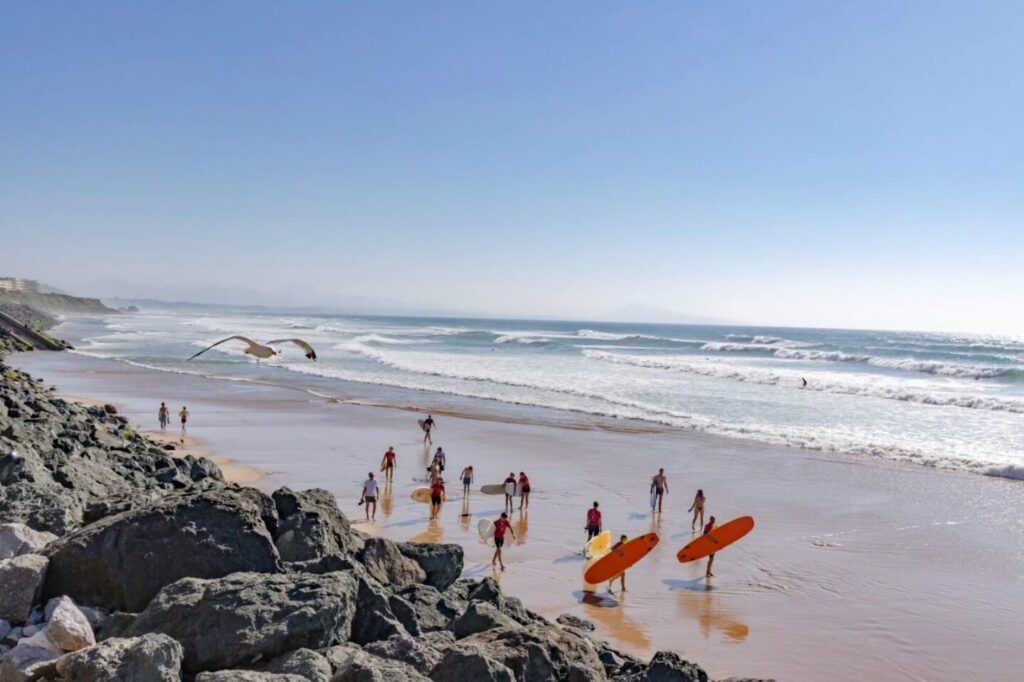Beginner surfing lesson in Biarritz with surfboards and waves