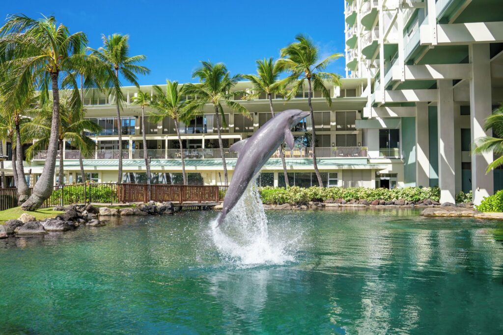 Exterior view of The Kahala Hotel & Resort in Honolulu, Oahu, featuring luxury beachfront views, tropical palm trees, and elegant resort architecture.