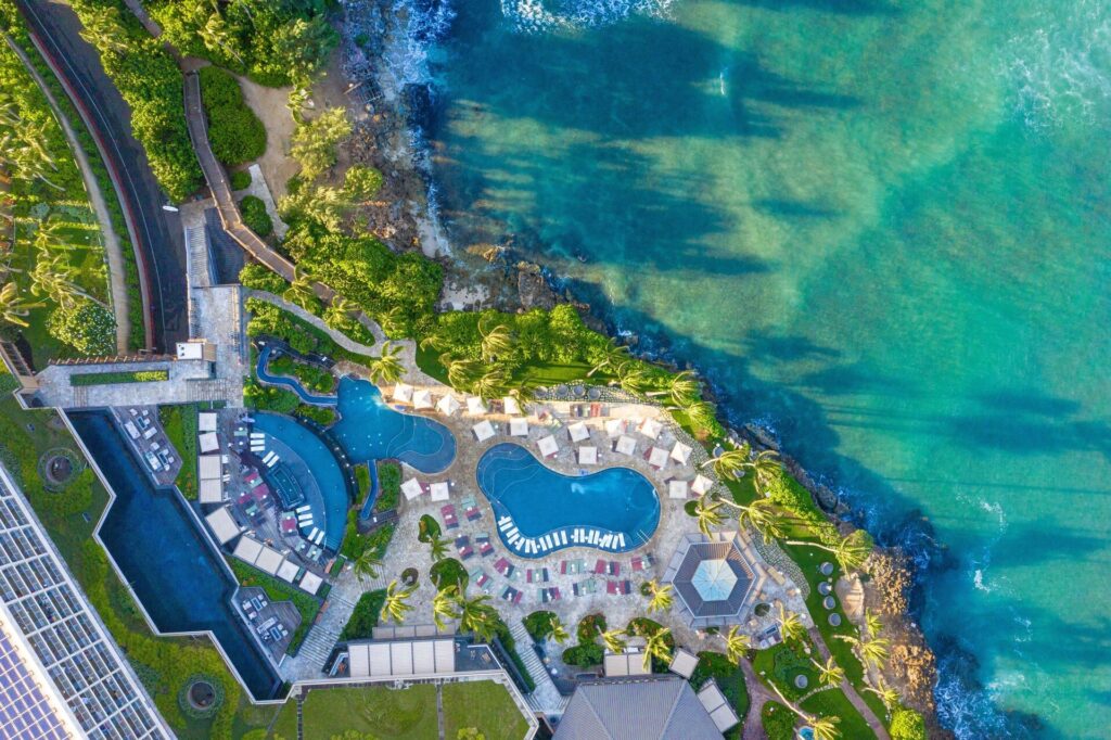 Exterior view of The Ritz-Carlton O'ahu, Turtle Bay on Oahu’s North Shore, featuring oceanfront luxury, scenic coastline views, tropical landscaping, and upscale resort architecture.