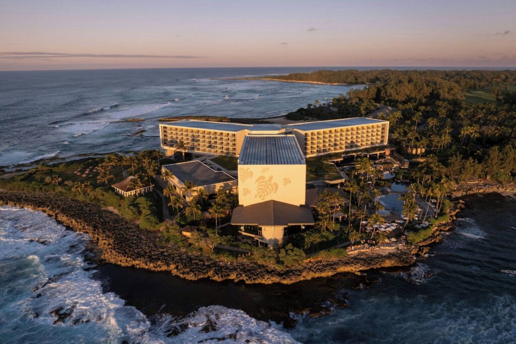 Exterior view of The Ritz-Carlton O'ahu, Turtle Bay on Oahu’s North Shore, featuring oceanfront luxury resort, rugged coastline views, lush tropical landscaping, and upscale modern architecture.